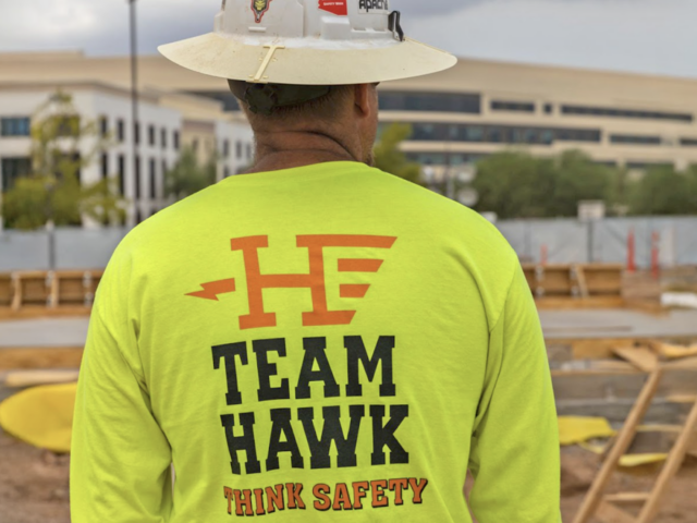 Someone in a hat wearing a Hawkeye Electric Shirt